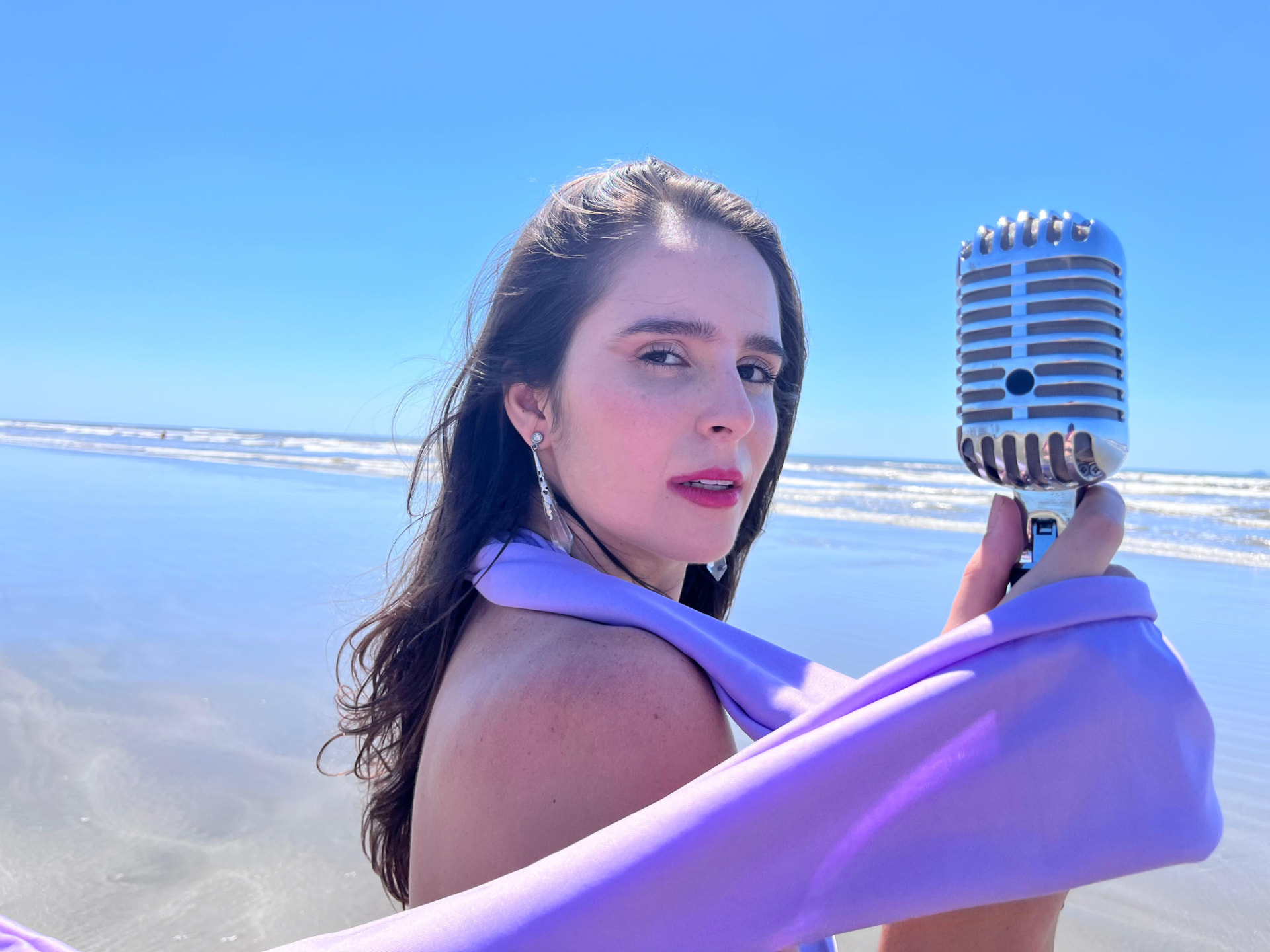 Giovana com microfone vintage na praia